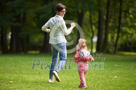 happy family playing together outdoor in park mother with kids running on grass happy family playing together outdoor in park mother with kids running on grass