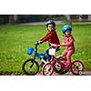 happy kids in park, boy and girl in nature with bicycle have fun