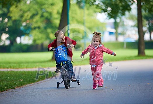 happy kids in park, boy and girl in nature with bicycle have fun happy kids in park, boy and girl in nature with bicycle have fun
