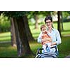 portrait of happy mom and baby daughter smiling at park nature