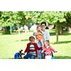 portrait of happy young family,  mother and  kids have fun in park