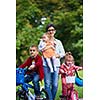 portrait of happy young family,  mother and  kids have fun in park