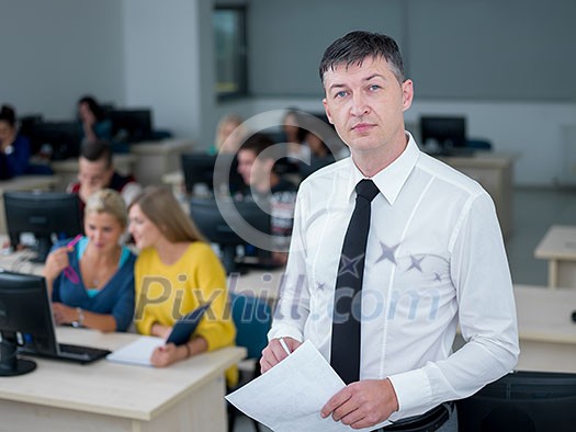 group of students with teacher in computer lab classrom learrning lessons,  get help and support