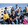 Group portrait  of happy  students outside sitting on steps have fun