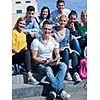 Group portrait  of happy  students outside sitting on steps have fun