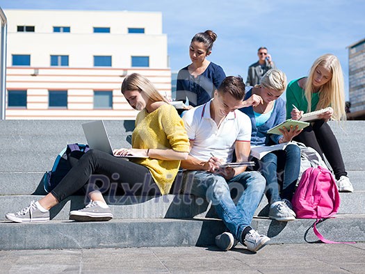 Group portrait of happy students outside sitting on steps have fun Group portrait of happy students outside sitting on steps have fun