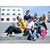 Group portrait  of happy  students outside sitting on steps have fun