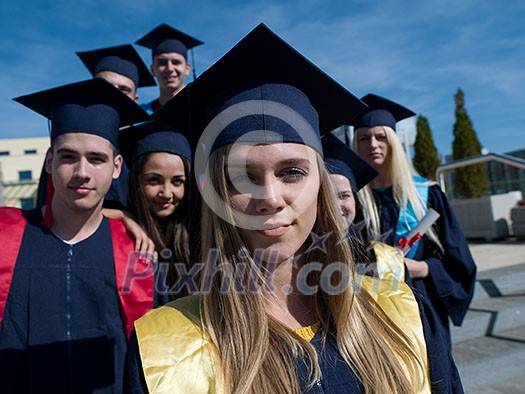 young graduates students group standing in front of university building on graduation day young graduates students group standing in front of university building on graduation day