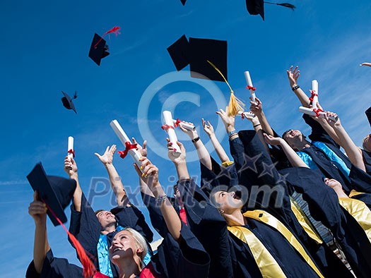 high school students graduates tossing up hats over blue sky. high school students graduates tossing up hats over blue sky.
