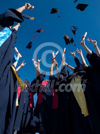 high school students graduates tossing up hats over blue sky. high school students graduates tossing up hats over blue sky.