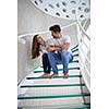 relaxed young couple on spiral glass stairs in modern home villa indoors