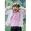 happy young girl posing and jumping with abstract urban style painting bacground begind