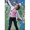 happy young girl posing and jumping with abstract urban style painting bacground begind