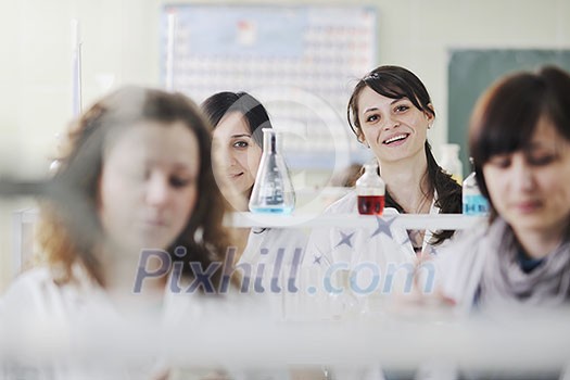 young woman students group in bright chemistry lab young woman students group in bright chemistry lab