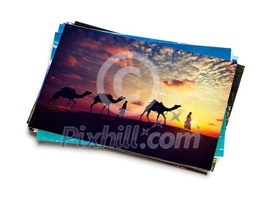 Holidays travel concept creative background - stack of vacation photos with camel caravan sunset image on top isolated on white background Holidays travel concept creative background - stack of vacation photos with camel caravan sunset image on top isolated on white background
