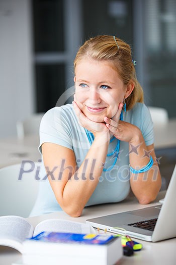 In the library - pretty, female student with books, papers and laptop computer working in a high school library (color toned image) In the library - pretty, female student with books, papers and laptop computer working in a high school library (color toned image)