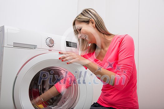 Housework: young woman doing laundry (shallow DOF; color toned image) Housework: young woman doing laundry (shallow DOF; color toned image)