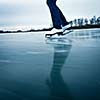 Young woman ice skating outdoors on a pond on a freezing winter day