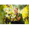 Beautiful woman in vineyard picking grape