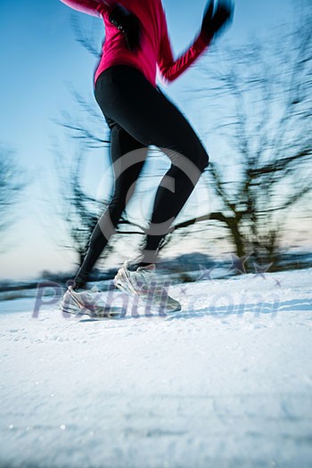 Young woman running outdoors on a cold winter day (motion blurred image) Young woman running outdoors on a cold winter day (motion blurred image)