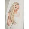 Gorgeous young woman/bride wearing a lovely dress, in a window, hiding in curtains(color toned image; shallow DOF)