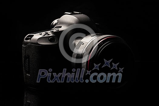 Professional modern DSLR camera low key image - Modern DSLR camera with a very wide aperture lens on Professional modern DSLR camera low key image - Modern DSLR camera with a very wide aperture lens on