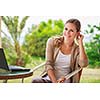 Portrait of a pretty young woman working on her computer on a terrace of her house