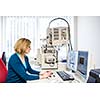 Pretty, female researcher using a microscope in a lab, doing research (color toned image)