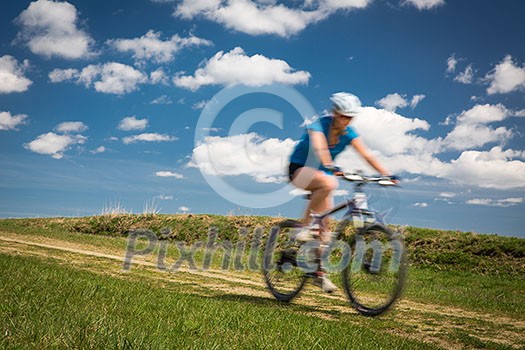 Pretty, young female biker outdoors on her mountain bike (shallow DOF; selective focus) Pretty, young female biker outdoors on her mountain bike (shallow DOF; selective focus)