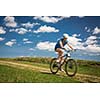 Pretty, young female biker outdoors on her mountain bike (shallow DOF; selective focus)