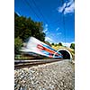 Fast train passing through a tunnel on a lovely summer day (motion blurred image)