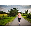 Young woman running outdoors on a lovely sunny winter/fall day