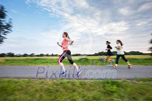 Young woman running outdoors on a lovely sunny winter/fall day (motion blurred image) Young woman running outdoors on a lovely sunny winter/fall day (motion blurred image)