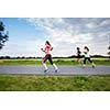 Young woman running outdoors on a lovely sunny winter/fall day (motion blurred image)