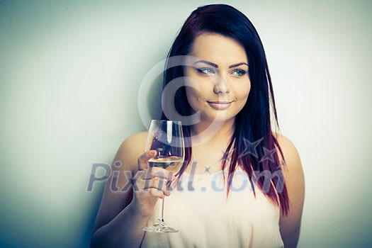 Pretty, young woman having a glass of wine (color toned image) Pretty, young woman having a glass of wine (color toned image)