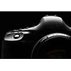Professional modern DSLR camera low key stock photo/image - Modern DSLR camera with a very wide aperture lens on with highlighted edges against black background