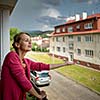 Pretty, young woman checking wether it is raining already from the balcony of her appartment