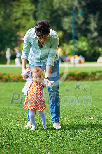 happy mother and baby child in park making first steps . Walking and hugging. happy mother and baby child in park making first steps . Walking and hugging.