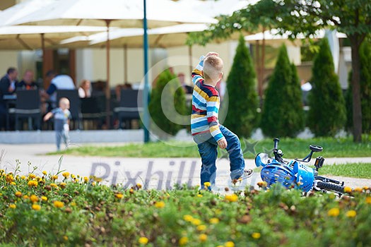 happy little boy have fun in park and learning to ride his first bike happy little boy have fun in park and learning to ride his first bike
