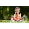 happy young baby child sittng on grass on beautiful summer day in park