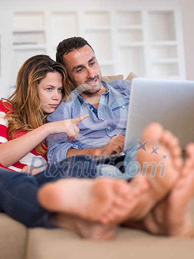 happy young relaxed couple working on laptop computer at modern home indoor happy young relaxed couple working on laptop computer at modern home indoor