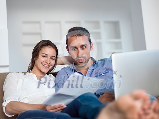happy young relaxed couple working on laptop computer at modern home indoor happy young relaxed couple working on laptop computer at modern home indoor