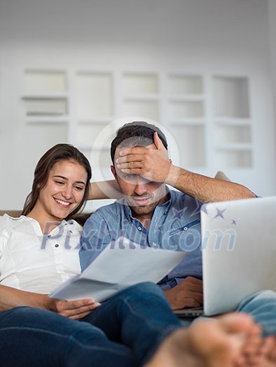 happy young relaxed couple working on laptop computer at modern home indoor happy young relaxed couple working on laptop computer at modern home indoor