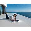 beautiful young woman relax and work on laptop computer  and read book at modern  home