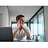 portrait of young happy business man working on laptop computer at home