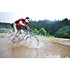 young man drive mountain bike over water river