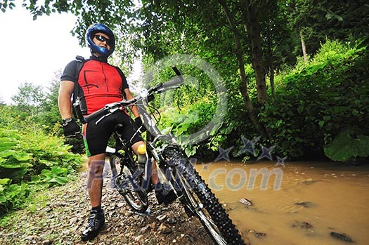 young man drive mountain bike over water river young man drive mountain bike over water river