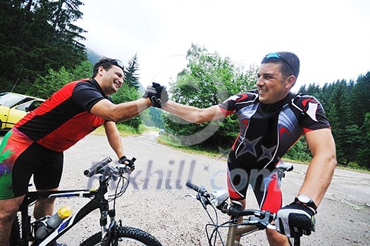 two friends have fun outdoor in nature and ride  on muntain bike