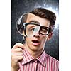 Young man scientist looking in magnifying glass