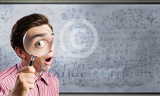 Young man scientist looking in magnifying glass Young man scientist looking in magnifying glass